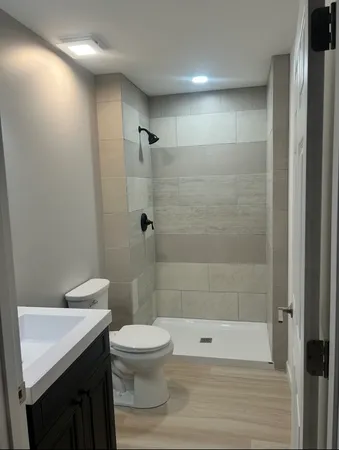a bathroom with a shower a toilet and a sink