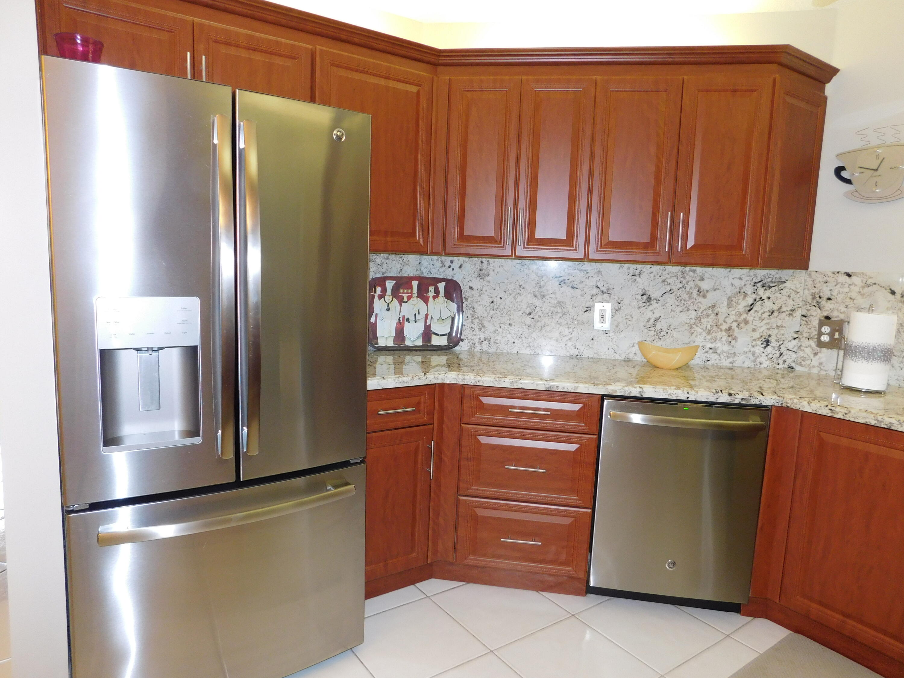 5235 Europa Drive, Unit E Boynton Beach, FL 33437 - Photo 13 of 57 a kitchen with stainless steel appliances granite countertop a refrigerator and a sink