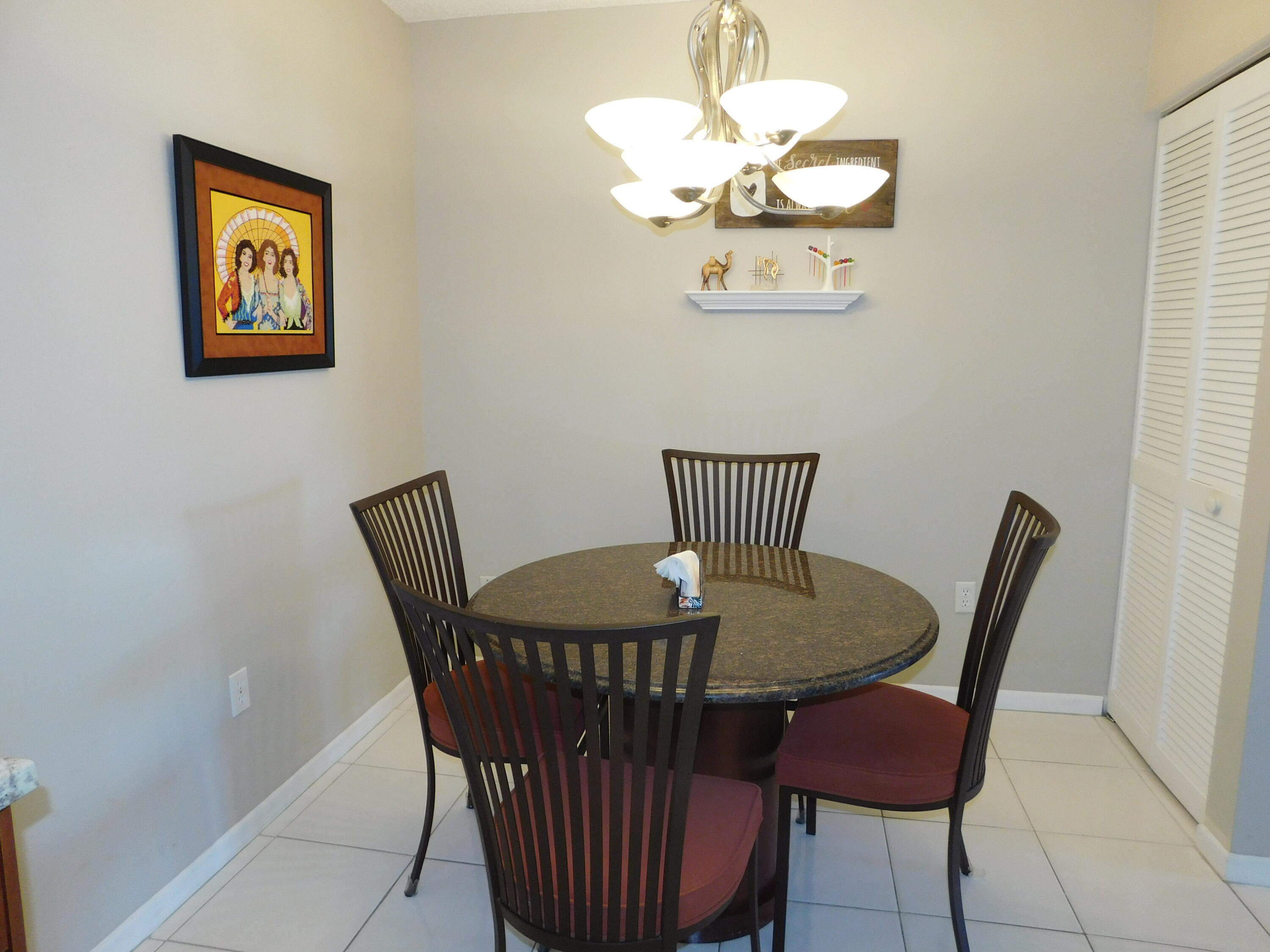 5235 Europa Drive, Unit E Boynton Beach, FL 33437 - Photo 14 of 57 a view of a dining room with furniture and chandelier