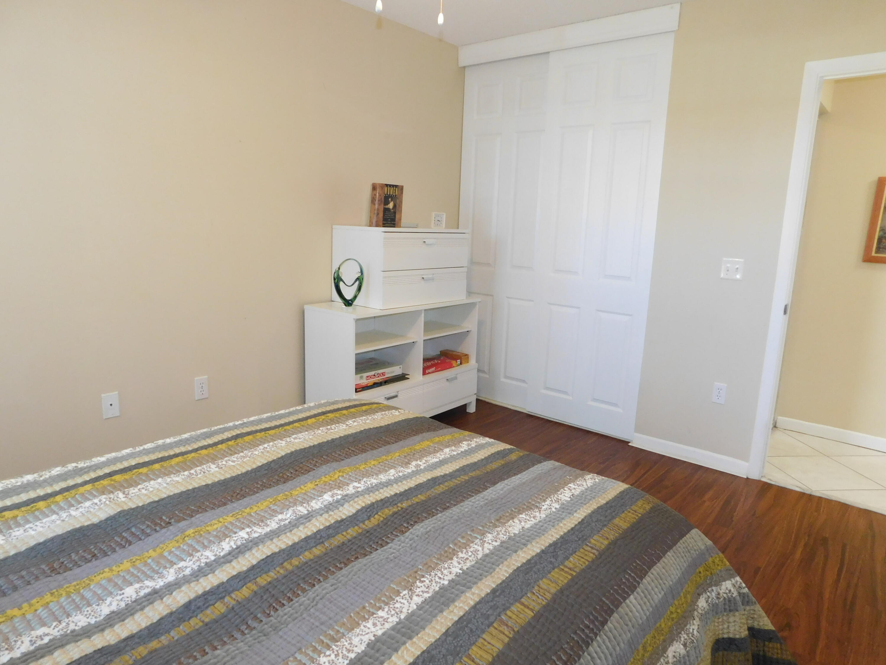 5235 Europa Drive, Unit E Boynton Beach, FL 33437 - Photo 25 of 57 a bedroom with a bed and cabinets