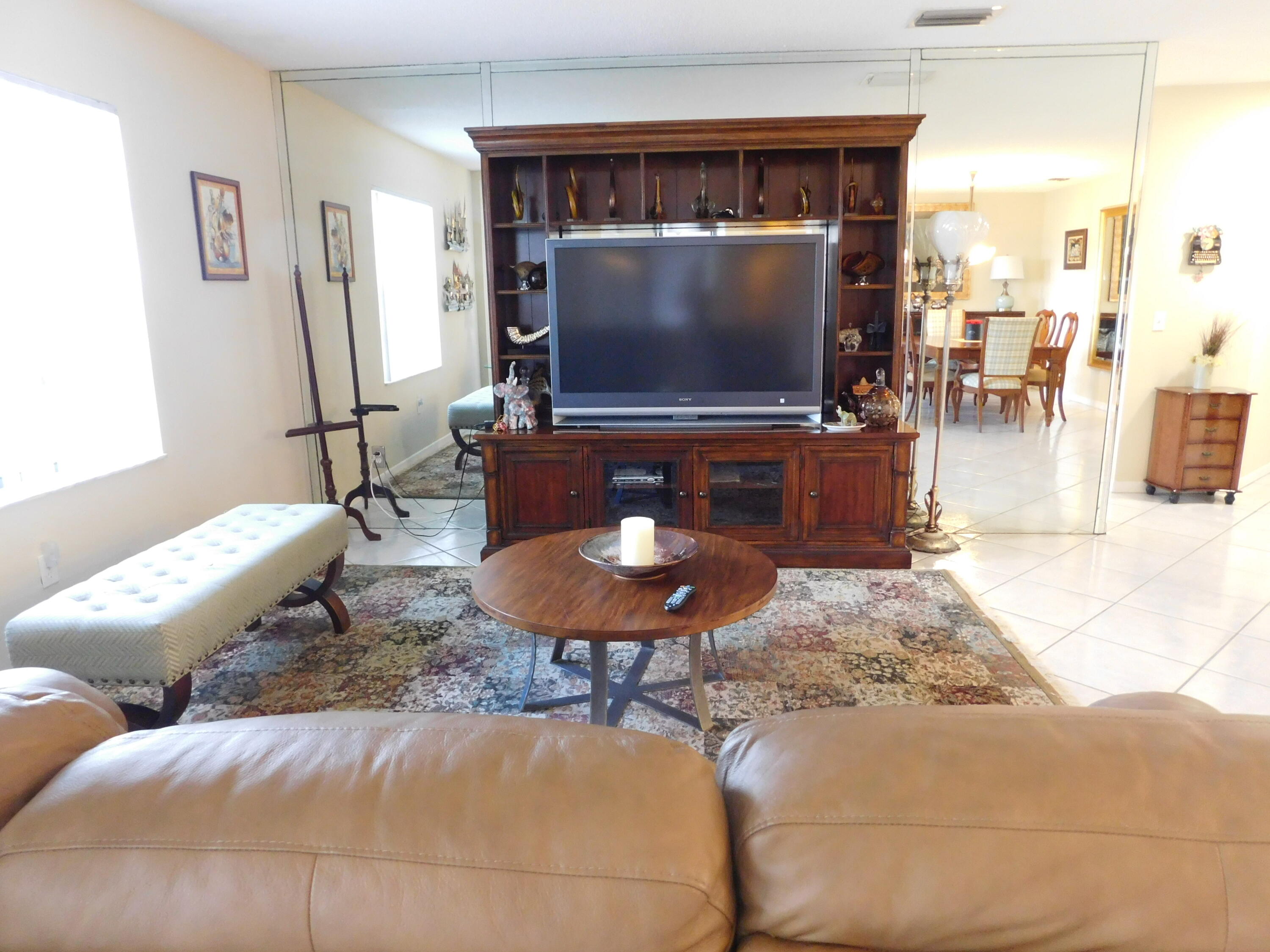 5235 Europa Drive, Unit E Boynton Beach, FL 33437 - Photo 8 of 57 a living room with furniture and a flat screen tv