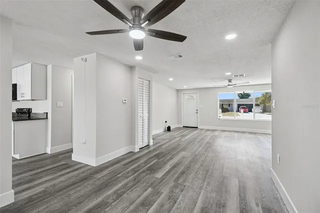 a living room with stainless steel appliances granite countertop furniture and wooden floor