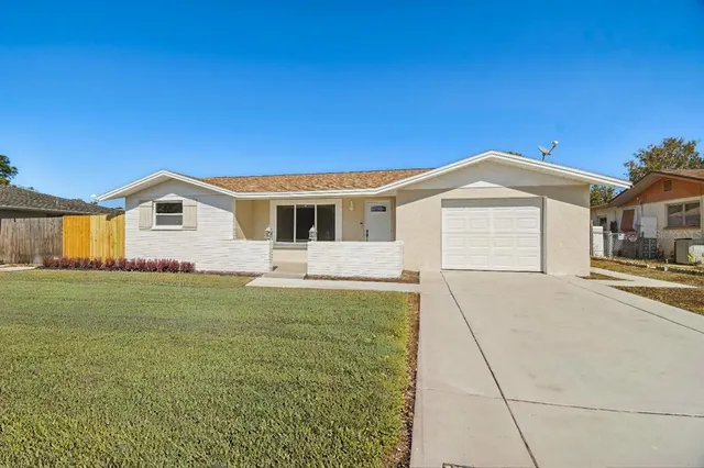 a view of an empty room with wooden floor and a ceiling fan