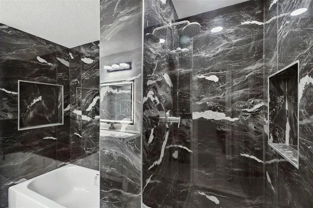 a bathroom with a sink a toilet and shower