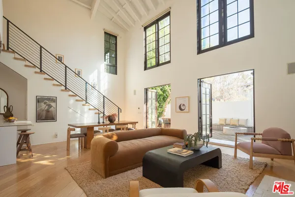 a living room with furniture and a floor to ceiling window
