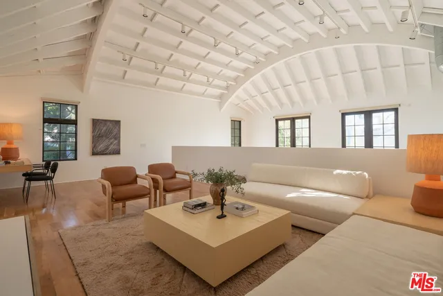 a view of a hallway to a livingroom with windows