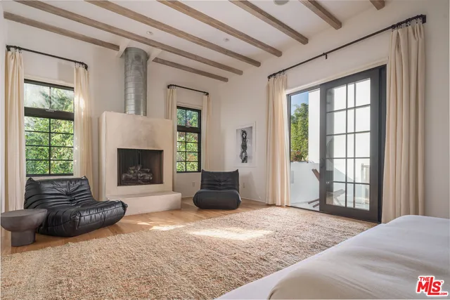 a bedroom with a bed a couch and a large window