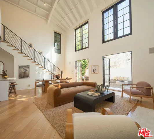 a living room with fireplace furniture and floor to ceiling windows