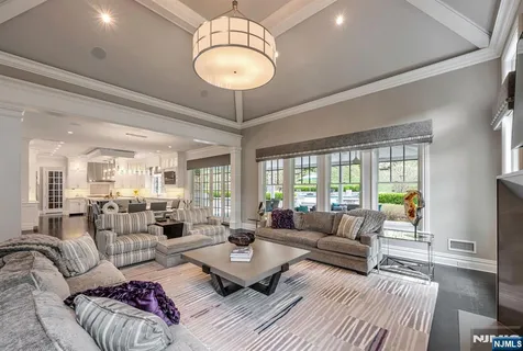 a living room with furniture chandelier and a large window