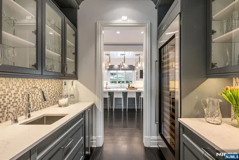 a kitchen with a sink and chairs