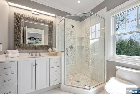 a bathroom with a shower sink vanity and toilet
