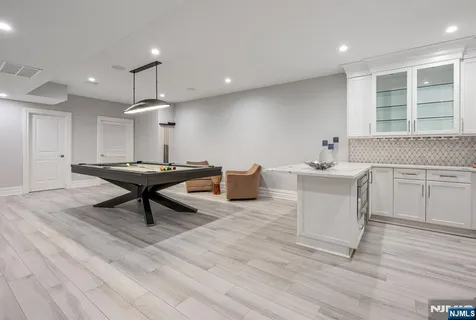 a living room with furniture a table and kitchen appliances