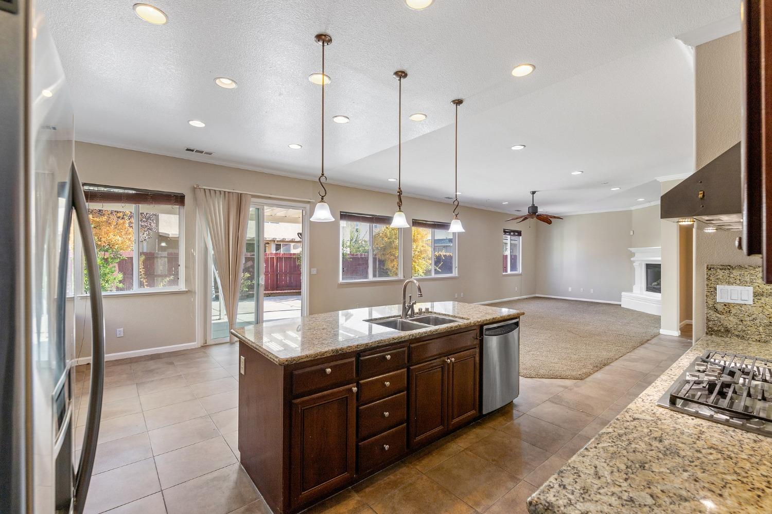 2090 Wisteria Place Manteca, CA 95337 - Photo 18 of 78 a kitchen with kitchen island granite countertop a sink and a large window