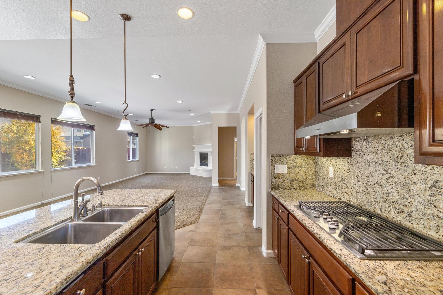 2090 Wisteria Place Manteca, CA 95337 - Photo 19 of 78 a kitchen with granite countertop stainless steel appliances a sink a stove cabinets and a counter top space