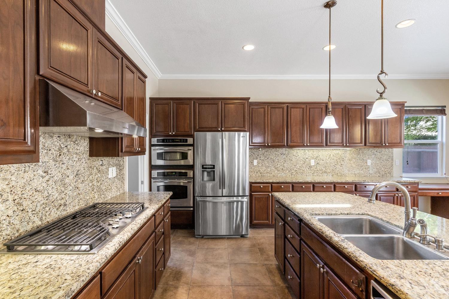 2090 Wisteria Place Manteca, CA 95337 - Photo 25 of 78 a kitchen with stainless steel appliances granite countertop a sink stove and refrigerator