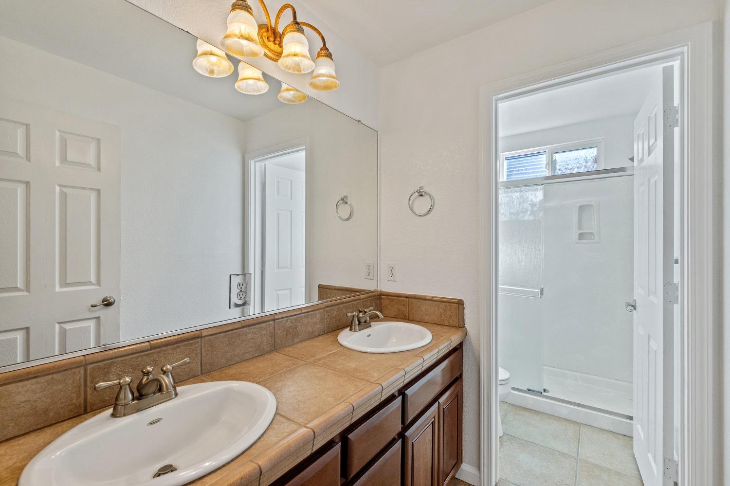 2090 Wisteria Place Manteca, CA 95337 - Photo 47 of 78 a bathroom with a sink double vanity granite tub and a mirror