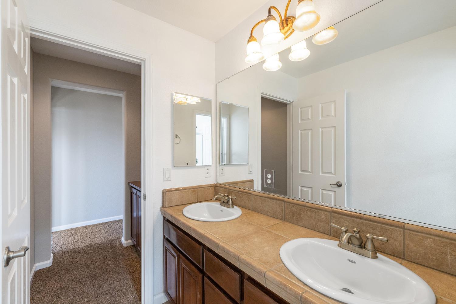 2090 Wisteria Place Manteca, CA 95337 - Photo 49 of 78 a bathroom with a sink a light fixture and a mirror