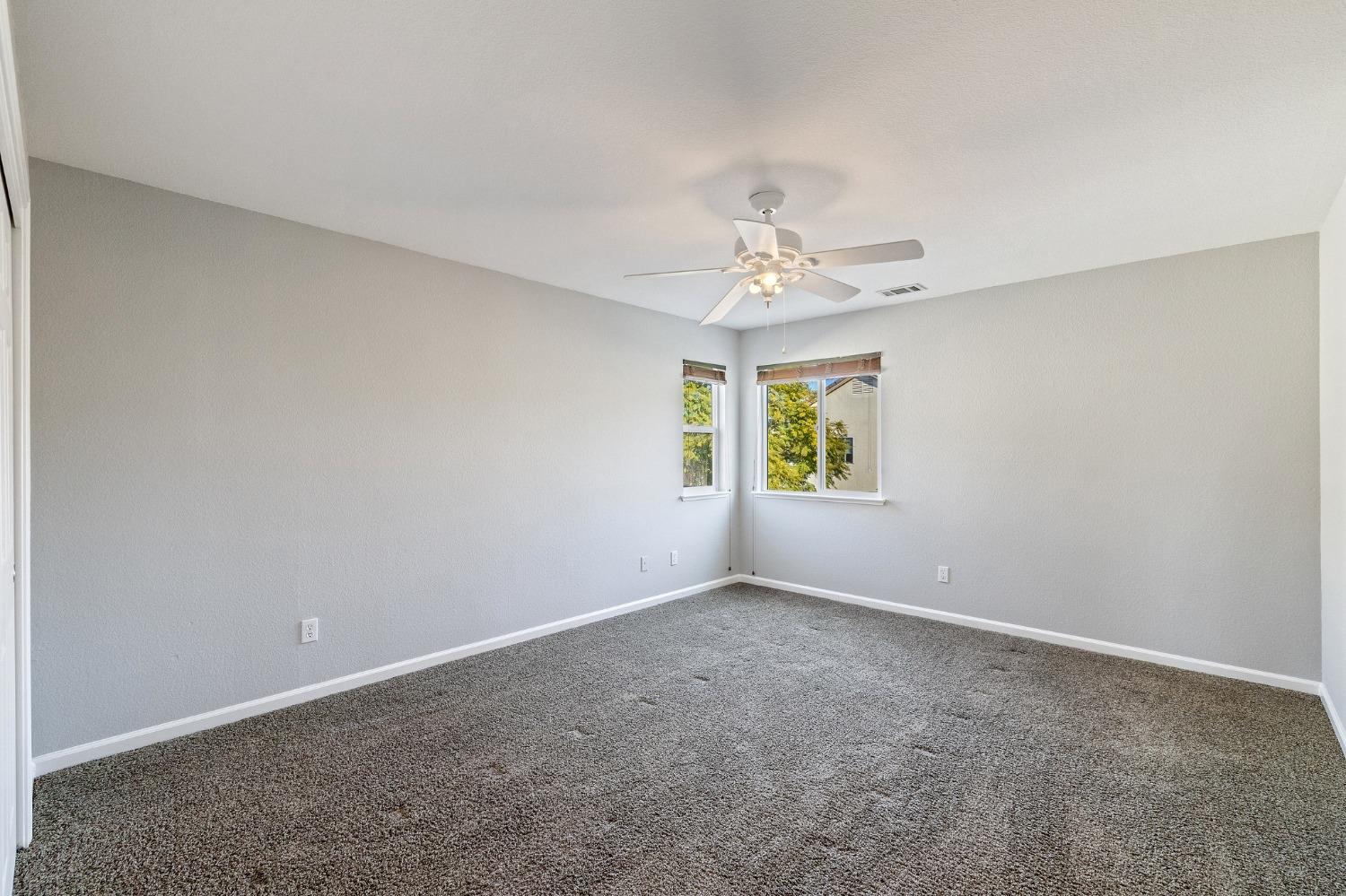 2090 Wisteria Place Manteca, CA 95337 - Photo 52 of 78 an empty room with windows and chandelier fan