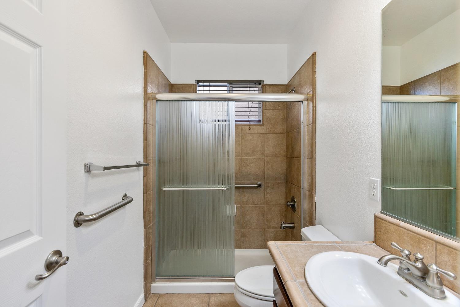 2090 Wisteria Place Manteca, CA 95337 - Photo 66 of 78 a bathroom with a shower a sink and a mirror