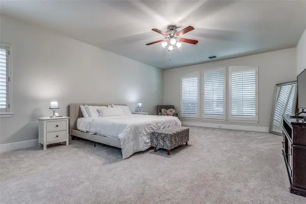 a spacious bedroom with a bed and a chandelier