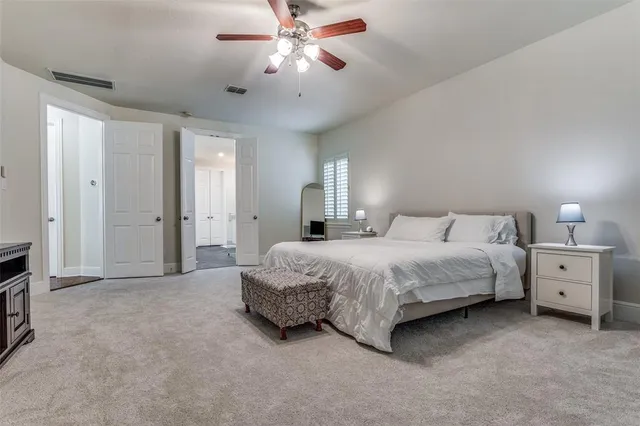 a spacious bedroom with a bed and a chandelier