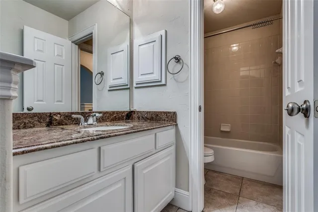a bathroom with a granite countertop sink a mirror and a bathtub