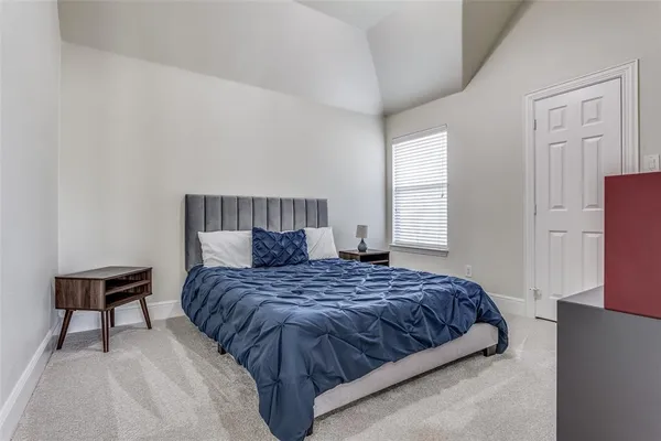 a bedroom with a bed and a lamp on table