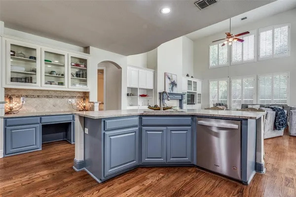 a kitchen with granite countertop a sink cabinets and wooden floor