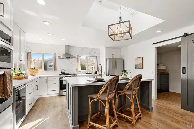 a view of a dining room with furniture a chandelier and wooden floor