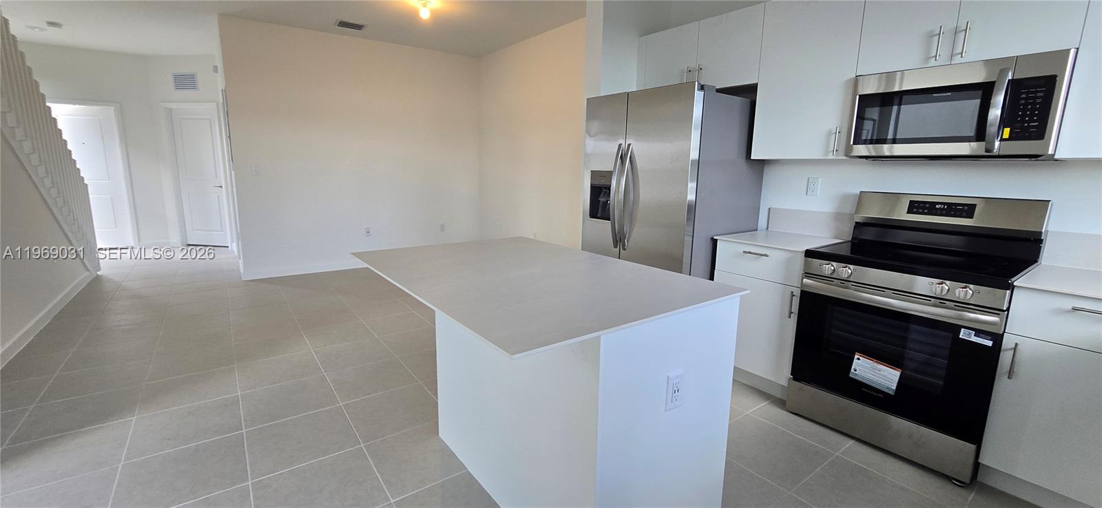 2729 Southeast 26th Road, Unit 2729 Homestead, FL 33035 - Photo 17 of 57 a kitchen with stainless steel appliances a stove microwave and refrigerator