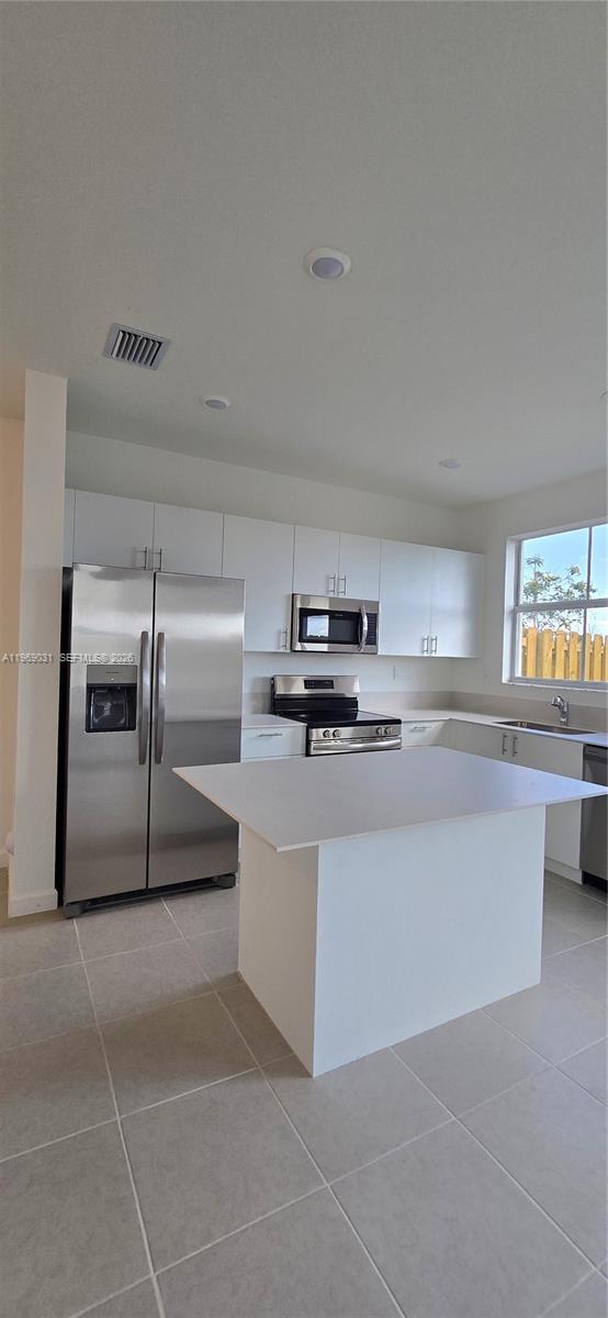 2729 Southeast 26th Road, Unit 2729 Homestead, FL 33035 - Photo 46 of 57 a kitchen with kitchen island cabinets and oven