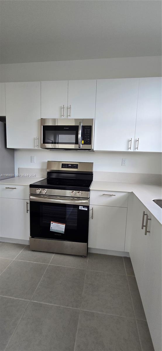2729 Southeast 26th Road, Unit 2729 Homestead, FL 33035 - Photo 50 of 57 a kitchen with a stove and white cabinets