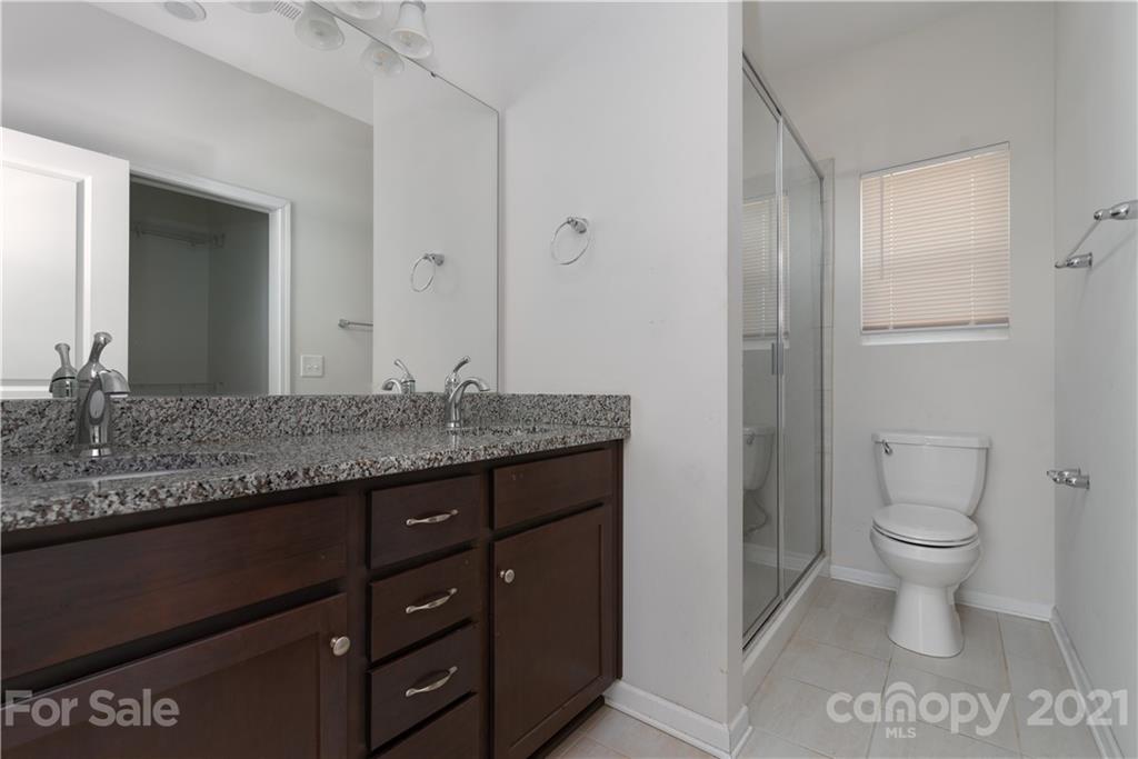 5027 Elizabeth Road Charlotte, NC 28269 - Photo 13 of 23 a bathroom with a granite countertop toilet a sink and a mirror