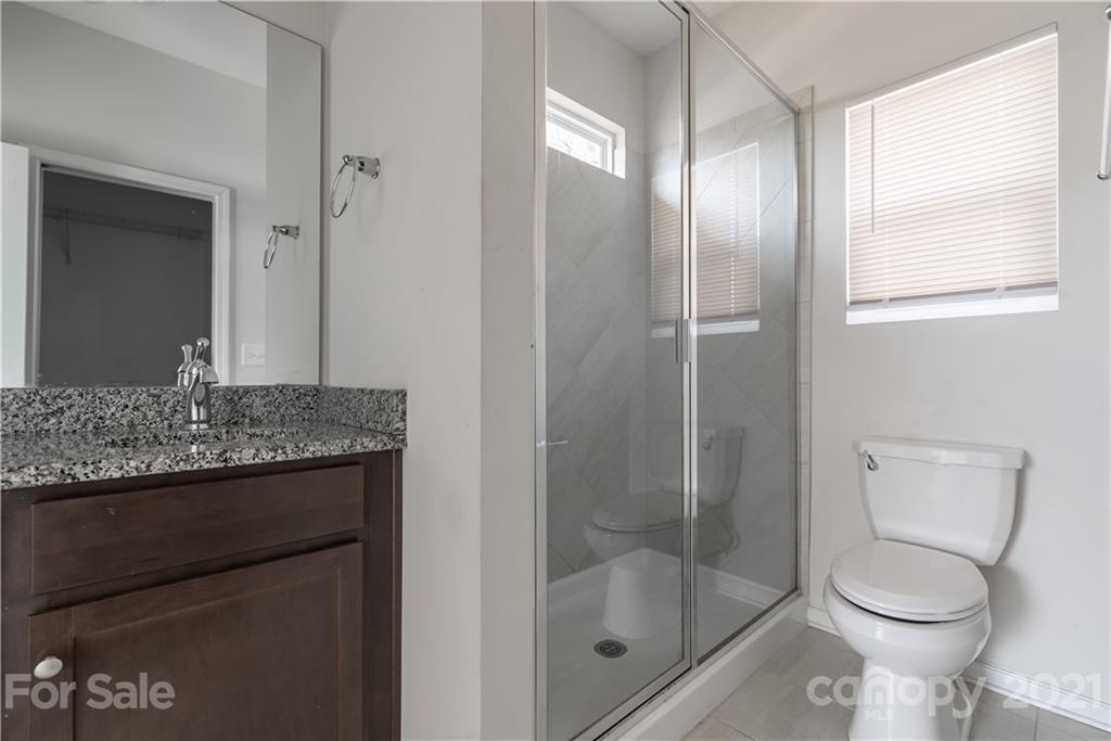 5027 Elizabeth Road Charlotte, NC 28269 - Photo 14 of 23 a bathroom with a granite countertop sink a toilet and shower