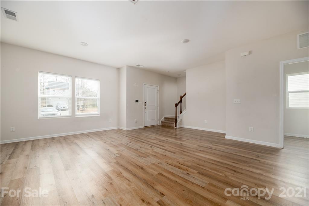 5027 Elizabeth Road Charlotte, NC 28269 - Photo 5 of 23 an empty room with wooden floor and windows