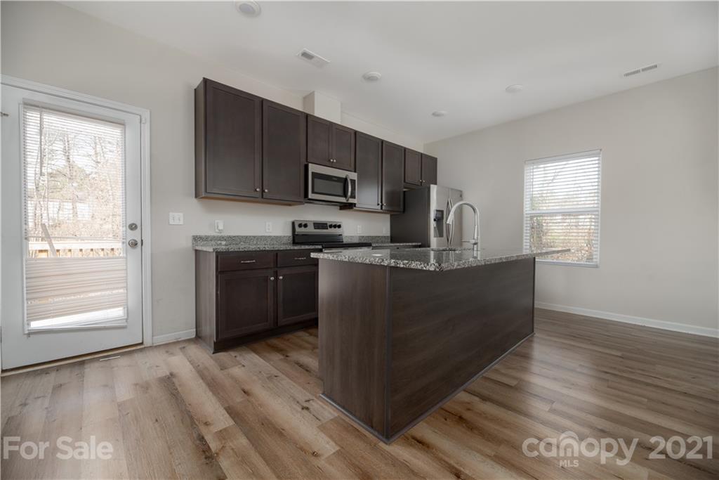 5027 Elizabeth Road Charlotte, NC 28269 - Photo 6 of 23 a kitchen with stainless steel appliances granite countertop a stove a sink and a refrigerator