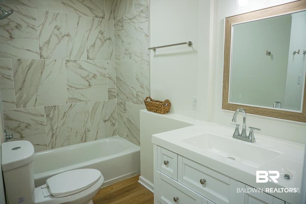 4734 Kirkwell Drive Mobile, AL 36619 - Photo 11 of 18 Full bathroom featuring tiled shower / bath, toilet, hardwood / wood-style flooring, and vanity