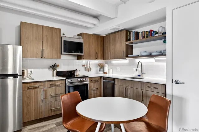 a kitchen with a sink a stove and chairs