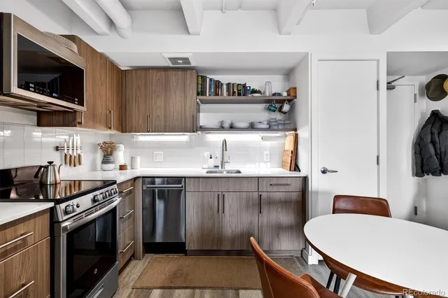 a kitchen with stainless steel appliances a stove microwave and refrigerator