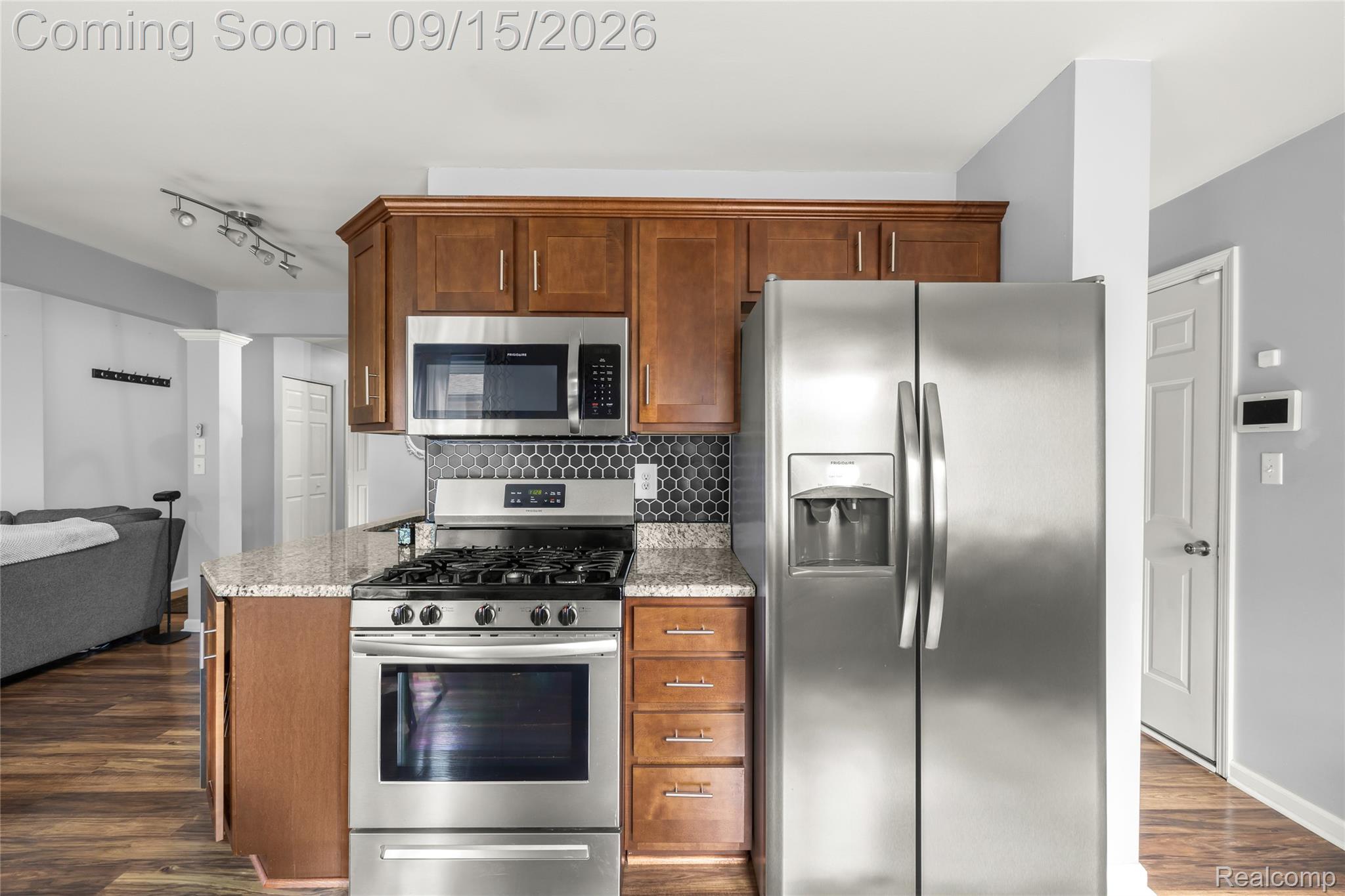 22947 Tuck Road Farmington, MI 48336 - Photo 8 of 34 Kitchen featuring stainless steel appliances, wood-finish cabinetry, granite-style countertops, and a hexagonal tile backsplash