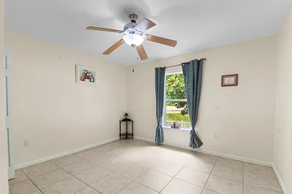 an empty room with windows and fan