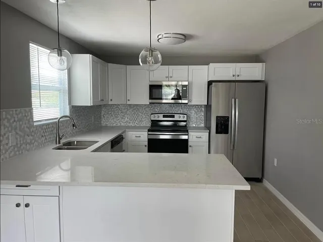 a kitchen with a refrigerator a sink a stove and cabinets