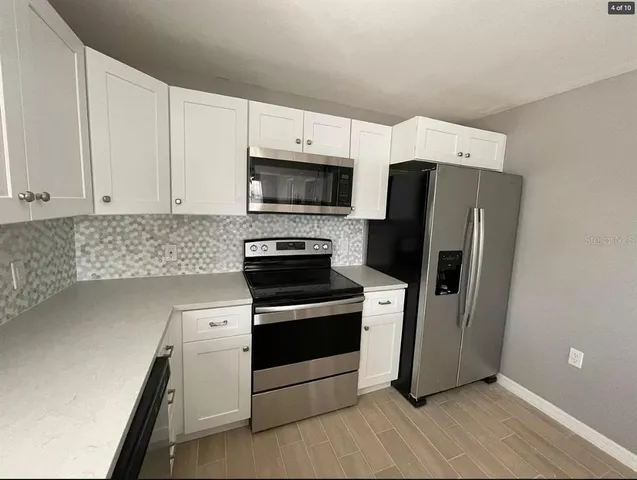 a kitchen with stainless steel appliances a refrigerator stove and microwave