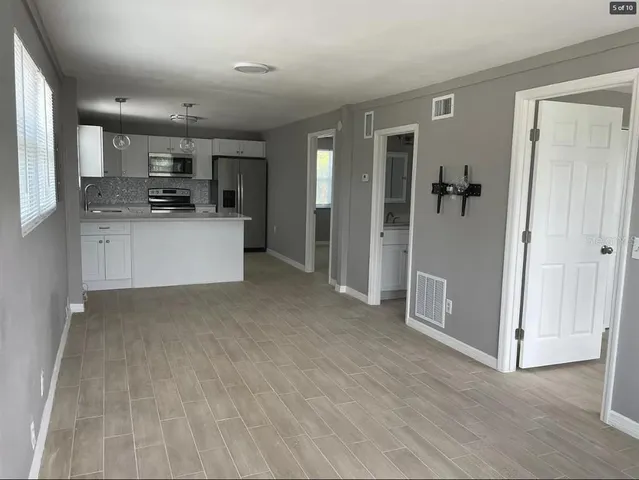 a view of kitchen with stainless steel appliances refrigerator sink and cabinets