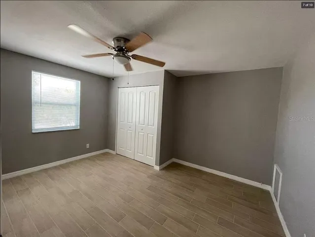 an empty room with windows and fan