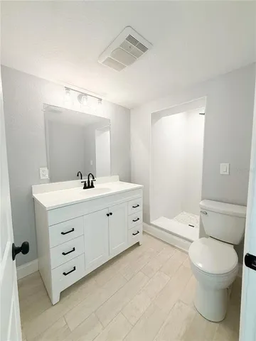 a bathroom with a double vanity sink toilet mirror and bathtub