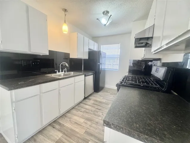 a kitchen with stainless steel appliances granite countertop a sink stove and cabinets