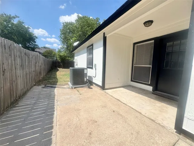 a view of a patio with table and chairs and wooden fence
