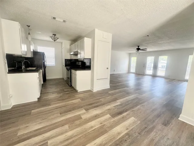 a view of a kitchen with a sink stainless steel appliances and cabinets