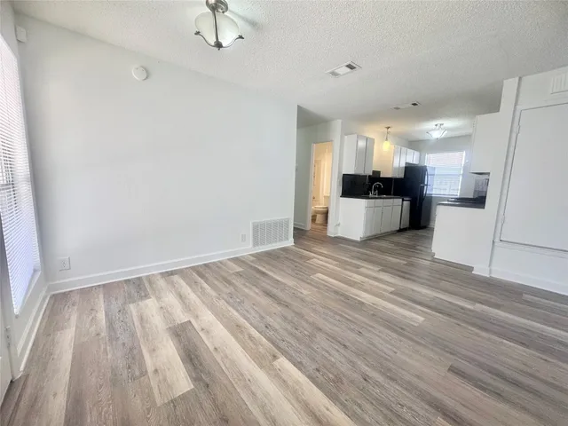 a view of kitchen and hall with wooden floor